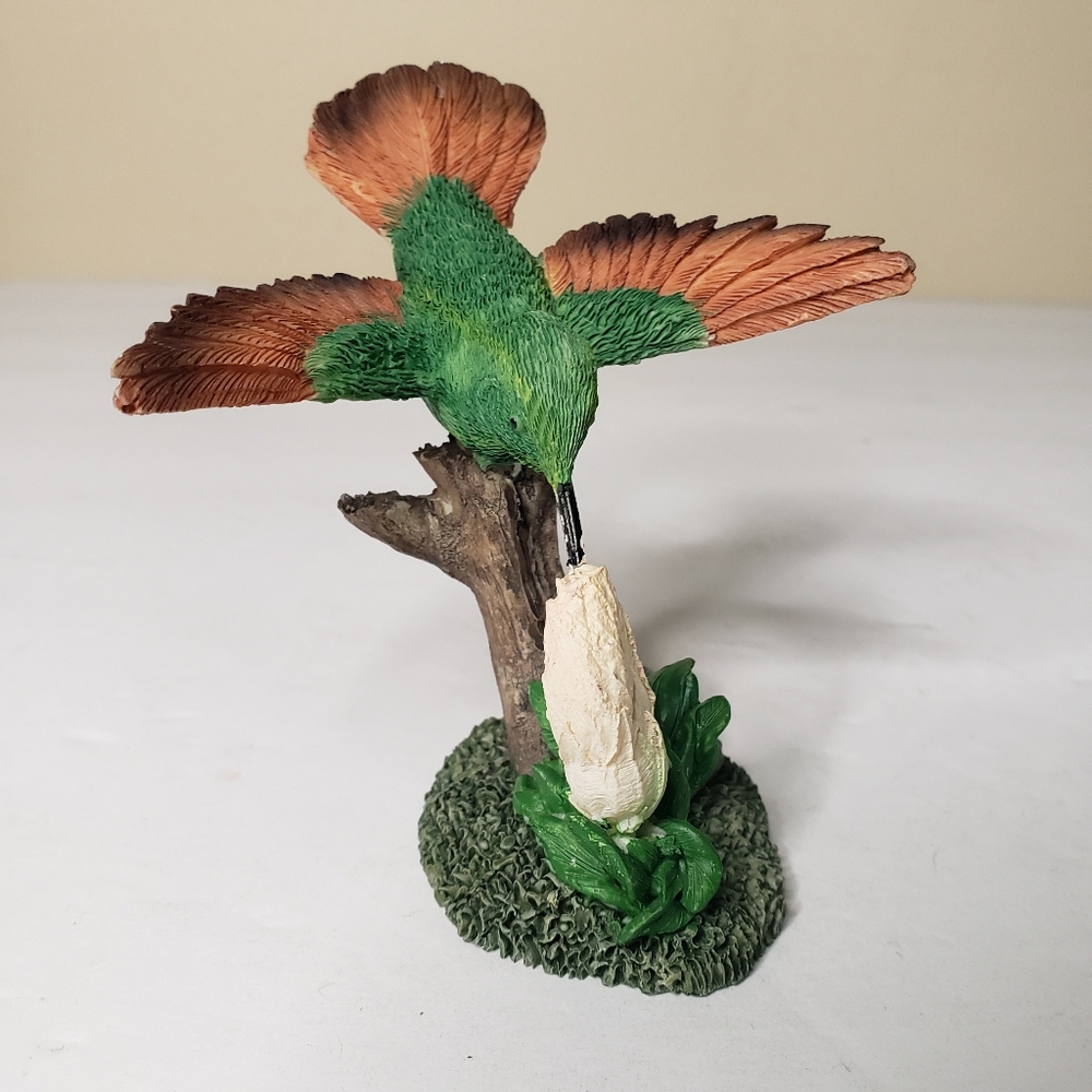 This is a detailed porcelain figurine of a Beryline hummingbird perched 140